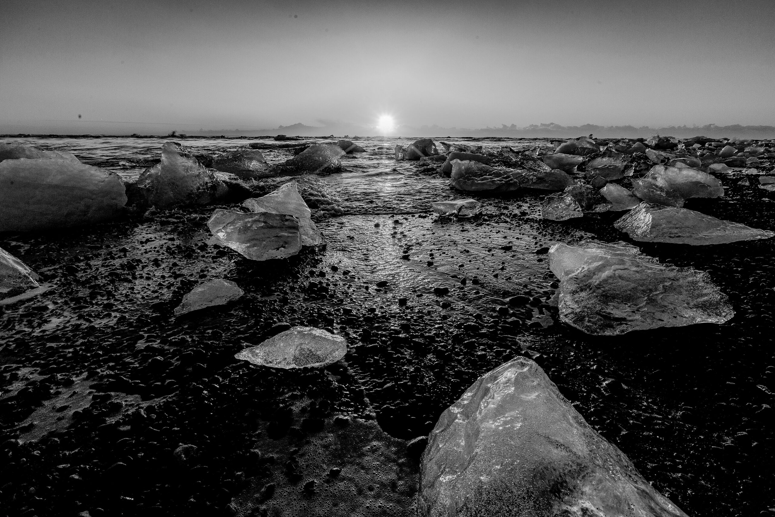 Expansive frozen landscape with scattered ice formations under a distant horizon, part of the Frozen Beauty series by Ebis Hernandez