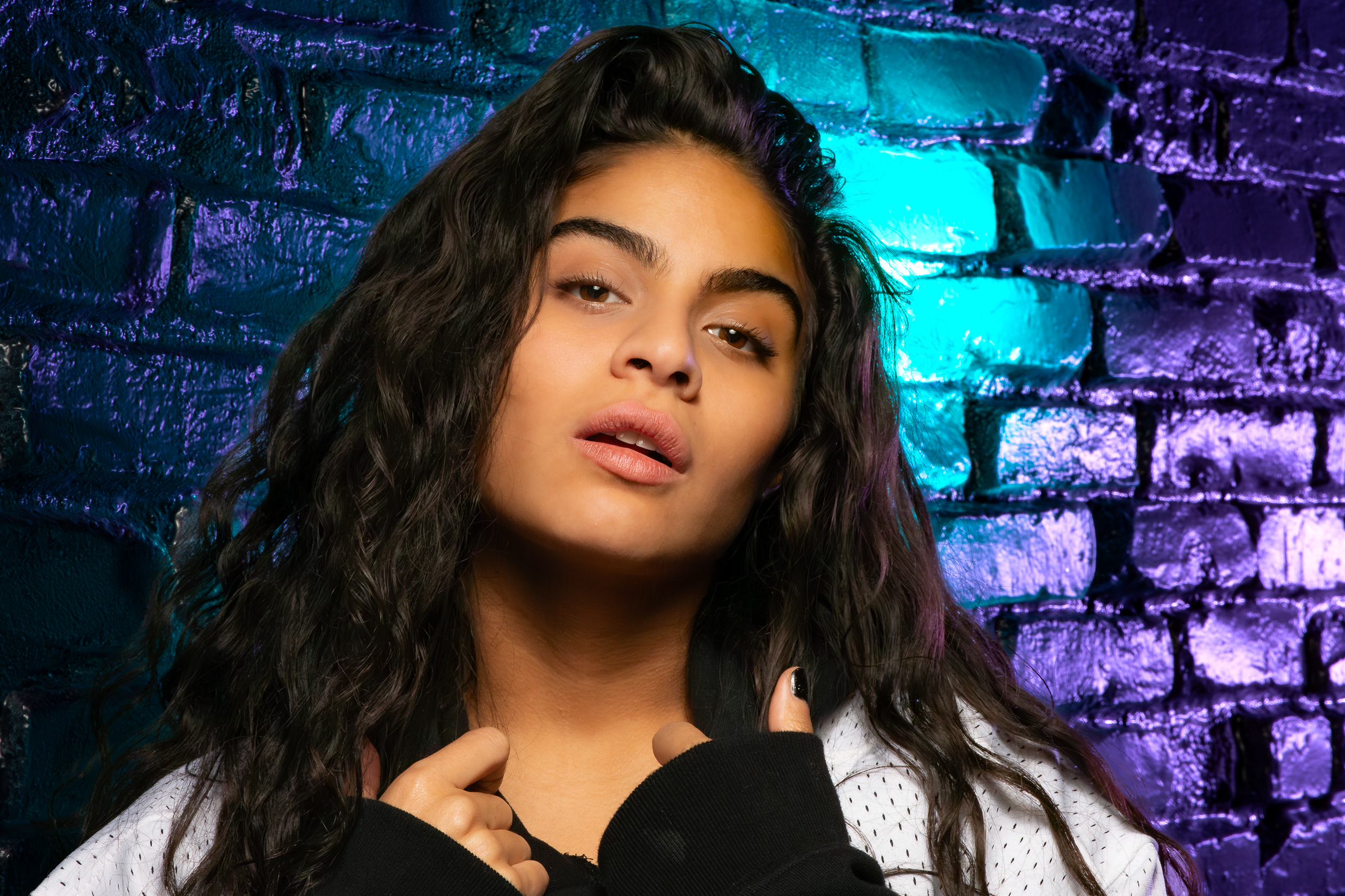 Close-up studio portrait of Jessie Reyez with vibrant lighting by photographer Ebis Hernandez
